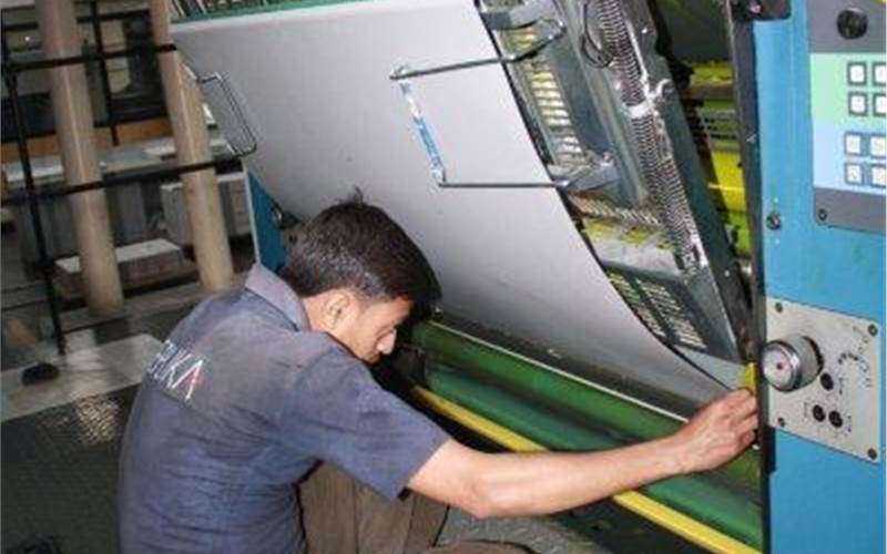 A printing press operator mounts the CTP plate on the press