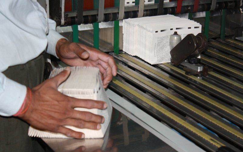 The folding machine operator collects the press signatures