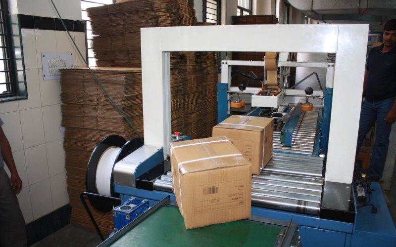 Once the books are packed in corrugated boxes after being sealed, each box is strap-packed