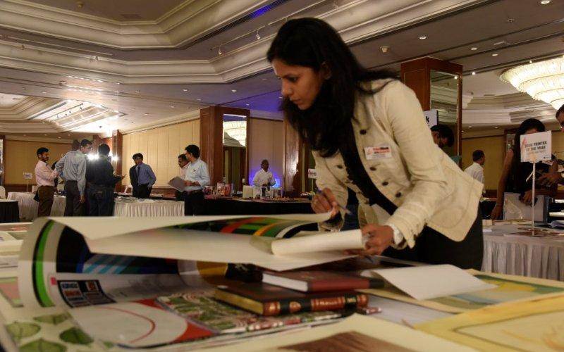 Vishakha Singh, executive director of Aurora Comms examining a print sample