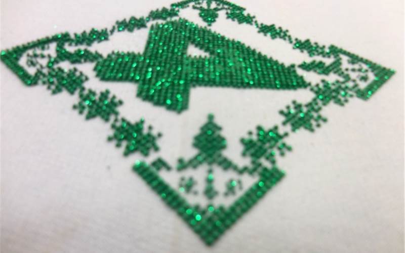 The image shows a high density glitter print. The high density inks used here is screen printed for five times. Finally, glitter is printed onto the print and cured