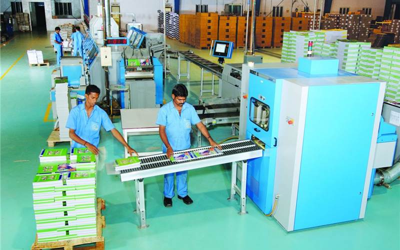 The Muller Martini Merit S three knife trimmer + conveyors work in harmony with the existing Acoro A5 binding line