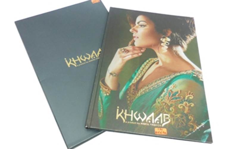 ALMATS BRANDING SOLUTION | Khwaab Aura Collection BookLength of run: 600Art: Text pages: CMYK and slipcase with Pantone 547CPre-Press: GMG Process systemPress: Ryobi 920 and SordzPost-Press: Aqueous coating on all pages plus gold foil stamping on slipcasePaper: Cover: 120gsm Stardream Diamond paper, text: 130gsm Ensemble pure white paper, slipcase: 350gsm white back duplex boardSpecial feature: Gold sticker pasting on the hardcase cover and punching and pasting on slipcase