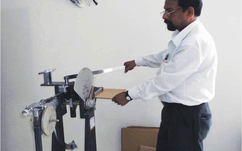 In the picture is a puncture resistance test in progress. It measures the energy required to punch through a corrugated board.