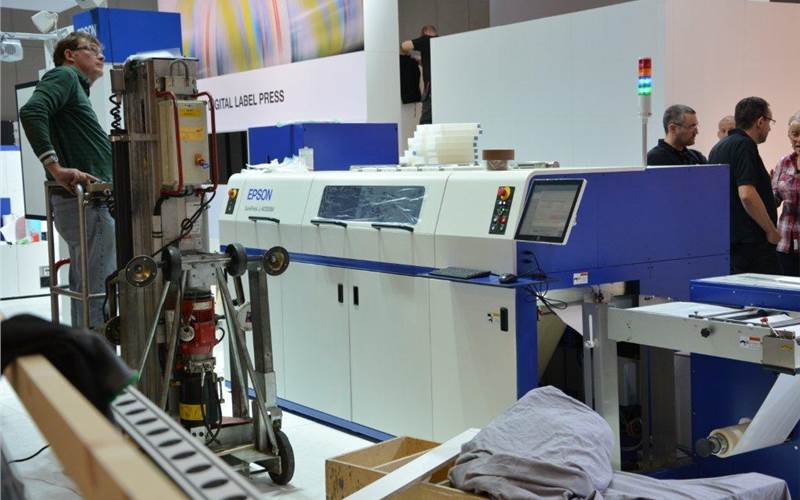Epson SurePress 4033AW is part of the many industrial label presses the company is show casing. Also see, GM’s laser cutting machine running next to the SurePress